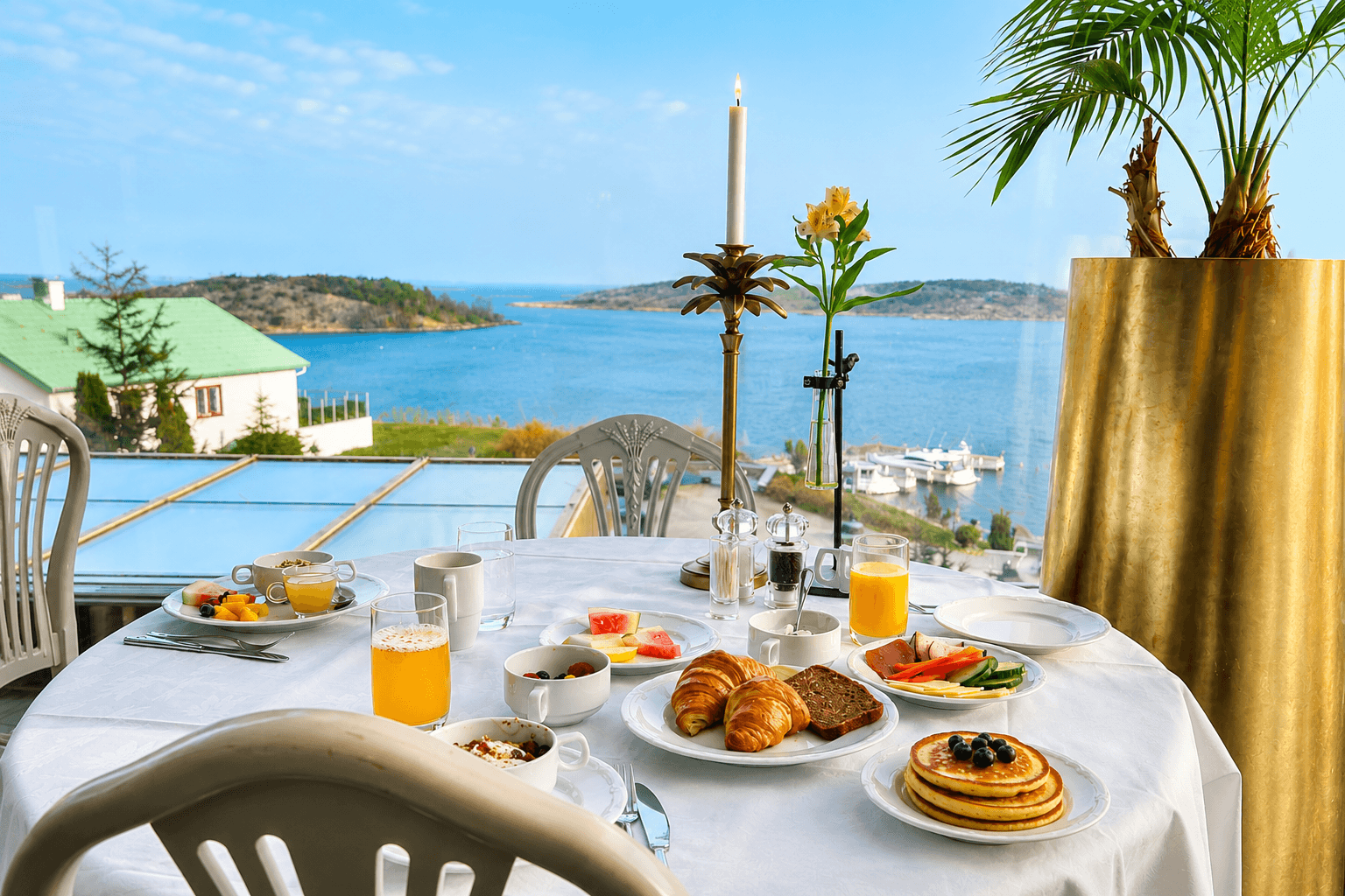 Frukostbuffé med pannkakor, frukt, ost och kaffe, med utsikt över havet